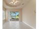 Bedroom featuring tile floors, tray ceiling, and sliding glass doors to the screened-in lanai at 5009 Sandy Brook Cir, Wimauma, FL 33598