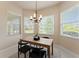 Breakfast nook features bright windows with backyard and lake views, and modern chandelier at 5009 Sandy Brook Cir, Wimauma, FL 33598