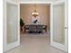 Dining room viewed through French doors offers a chandelier and large table at 5009 Sandy Brook Cir, Wimauma, FL 33598