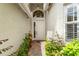 Front door entrance featuring a classic white door, brick walkway, and well-maintained landscaping at 5009 Sandy Brook Cir, Wimauma, FL 33598