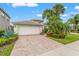 Beautiful single-story home boasting a well-kept lawn and a brick driveway leading to a two-car garage at 5009 Sandy Brook Cir, Wimauma, FL 33598