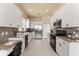 Bright kitchen features granite countertops, white cabinetry, stainless steel appliances and neutral tile flooring at 5009 Sandy Brook Cir, Wimauma, FL 33598