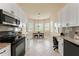 Kitchen with granite countertops, white cabinets, stainless steel appliances, and an adjacent breakfast nook at 5009 Sandy Brook Cir, Wimauma, FL 33598