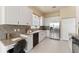 Well-lit kitchen featuring white cabinetry, stainless steel appliances, and granite countertops with a built-in desk at 5009 Sandy Brook Cir, Wimauma, FL 33598