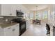 Kitchen with white cabinets, stainless appliances, granite counters, and breakfast nook with views at 5009 Sandy Brook Cir, Wimauma, FL 33598