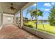 Enclosed lanai overlooks a peaceful lake view with swaying palms at 5009 Sandy Brook Cir, Wimauma, FL 33598
