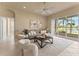 Serene living area offering comfortable seating, a ceiling fan, and sliding glass doors to the lanai and water view at 5009 Sandy Brook Cir, Wimauma, FL 33598