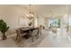 Open-concept living and dining area featuring tile floors, a modern chandelier, and views of the water at 5009 Sandy Brook Cir, Wimauma, FL 33598