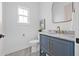 Powder room with blue vanity, marble countertop, gold fixtures, and stylish mirror at 5120 3Rd N Ave, St Petersburg, FL 33710