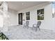 Inviting front porch features stylish gray chairs, a tiled floor, and an elegant black front door with glass accents at 5120 3Rd N Ave, St Petersburg, FL 33710