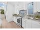 Well-lit kitchen featuring white cabinetry, marble backsplash, countertops and stainless steel range at 5120 3Rd N Ave, St Petersburg, FL 33710