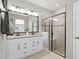 Elegant bathroom featuring double vanity with granite countertop and sleek glass enclosed shower at 520 Valri Park Dr, Valrico, FL 33594