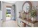 Inviting entryway with a decorative console table, round mirror, and light wood-look flooring at 520 Valri Park Dr, Valrico, FL 33594