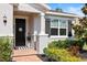 Welcoming front entrance with a stylish black door, manicured shrubs and attractive black shutters at 520 Valri Park Dr, Valrico, FL 33594