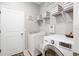 Efficient laundry room boasts modern washer and dryer and well organized shelves with storage boxes at 520 Valri Park Dr, Valrico, FL 33594