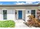 Inviting front entrance featuring a vibrant blue door and meticulously landscaped surroundings at 5215 Denver Ne St, St Petersburg, FL 33703