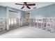 Light-filled living room with pastel blue walls, a ceiling fan and exposed studs, offering customization potential at 5215 Denver Ne St, St Petersburg, FL 33703