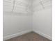 Walk-in closet featuring metal shelving and beige carpeting at 5270 Neil Dr, St Petersburg, FL 33714