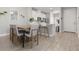 Bright dining area features wood-look tile, modern table setting, and open flow to the kitchen at 5270 Neil Dr, St Petersburg, FL 33714