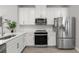 Well-equipped kitchen featuring stainless steel appliances, white cabinetry, and ample countertop space for cooking at 5270 Neil Dr, St Petersburg, FL 33714