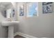 Well-lit half bath with a pedestal sink, decorative nautical artwork, and modern fixtures at 5270 Neil Dr, St Petersburg, FL 33714
