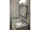 Bathroom vanity with gray marble countertop, white cabinets, and decorative mirror and light fixture at 5530 80Th N St # A306, St Petersburg, FL 33709