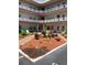 Exterior view of a multi-story building with landscaped courtyard, white Adirondack chairs, and walkways at 5530 80Th N St # A306, St Petersburg, FL 33709