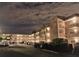The multi-story building exterior has lighted balconies, palm trees, and parking at 5530 80Th N St # A306, St Petersburg, FL 33709