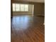 Living room with hardwood floors and a large window with shutter-style blinds at 5530 80Th N St # A306, St Petersburg, FL 33709