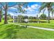 Scenic pond with a fountain surrounded by green grass, mature trees and condo buildings at 5530 80Th N St # A306, St Petersburg, FL 33709