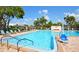Community pool with a variety of seating, a pool lift, and tropical landscaping at 5530 80Th N St # A306, St Petersburg, FL 33709