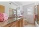 Bright bathroom featuring granite countertop, undermount sink, and glass-enclosed tub shower at 5901 3Rd S St, St Petersburg, FL 33705