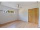 Minimalist bedroom with light wood floors and a closet, illuminated by natural light at 5901 3Rd S St, St Petersburg, FL 33705