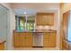 Kitchen features wood cabinets, stainless steel dishwasher and sink overlooking yard at 5901 3Rd S St, St Petersburg, FL 33705