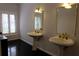 Bathroom with dual pedestal sinks and elegant gold framed mirrors at 6160 Fitzgerald Road, Odessa, FL 33556