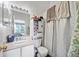 Bathroom with a toilet, vanity, mirror, and shower behind a decorative curtain at 6249 Osprey Lake Cir, Riverview, FL 33578