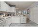 Bright kitchen with white cabinets and countertops featuring a view into the living area at 6249 Osprey Lake Cir, Riverview, FL 33578
