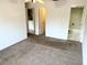 Spacious bedroom with carpet flooring, fan, and access to laundry and bathroom at 647 Fairmont Ave # C, Safety Harbor, FL 34695