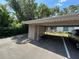 Assigned carport parking featuring a covered space and storage room in a quiet community at 647 Fairmont Ave # C, Safety Harbor, FL 34695