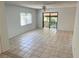 Open-concept living room featuring light tile flooring and a sliding glass door to the balcony at 647 Fairmont Ave # C, Safety Harbor, FL 34695