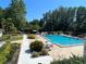 Community pool area with lounge chairs and lush landscaping at 647 Fairmont Ave # C, Safety Harbor, FL 34695