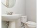 This half bathroom features a pedestal sink and round mirror at 6954 Hawthorne Trace Ln, Riverview, FL 33578