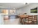 Bright dining area featuring a wood table set for four, with natural light and an open view to the living room at 6954 Hawthorne Trace Ln, Riverview, FL 33578