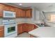 Well-equipped kitchen with stainless steel sink, white countertops, and wood cabinets, offering a functional layout at 6954 Hawthorne Trace Ln, Riverview, FL 33578