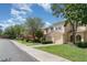 Street view of townhomes showcasing manicured lawns, mature trees, and well-maintained exteriors under a sunny sky at 6954 Hawthorne Trace Ln, Riverview, FL 33578