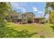 Expansive backyard with a two-story home, brick patio, and covered porch at 768 Pinellas Point S Dr, St Petersburg, FL 33705