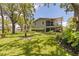 Lush backyard showcasing mature trees, green grass, and a screened-in porch at 768 Pinellas Point S Dr, St Petersburg, FL 33705