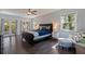 Comfortable primary bedroom with ample natural light, dark wood floors, a ceiling fan, and french doors to the lanai at 768 Pinellas Point S Dr, St Petersburg, FL 33705