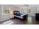 Comfortable primary bedroom with ample natural light, dark wood floors, a ceiling fan, and a soothing color palette at 768 Pinellas Point S Dr, St Petersburg, FL 33705