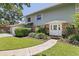 Home exterior featuring a manicured lawn, brick accents, and a walkway leading to the front door at 768 Pinellas Point S Dr, St Petersburg, FL 33705
